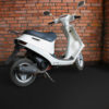 White scooter in corner wall