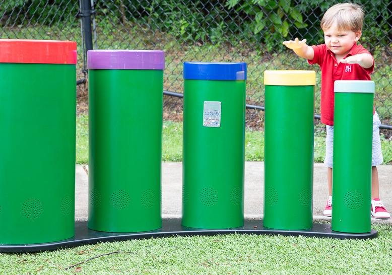 Toddler playing Rainbow Tuned Drums at playground