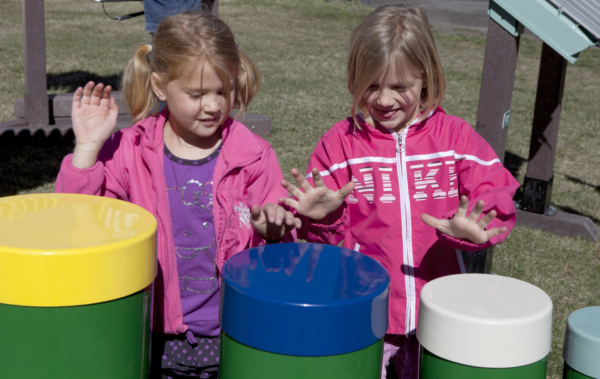 Children playing Rainbow Tuned Drums at park